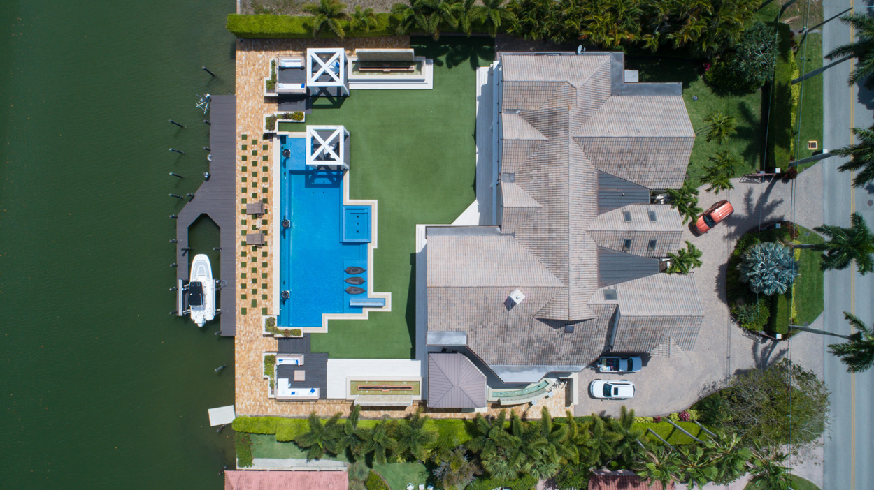 bird's eye view of a house with a pool by the water