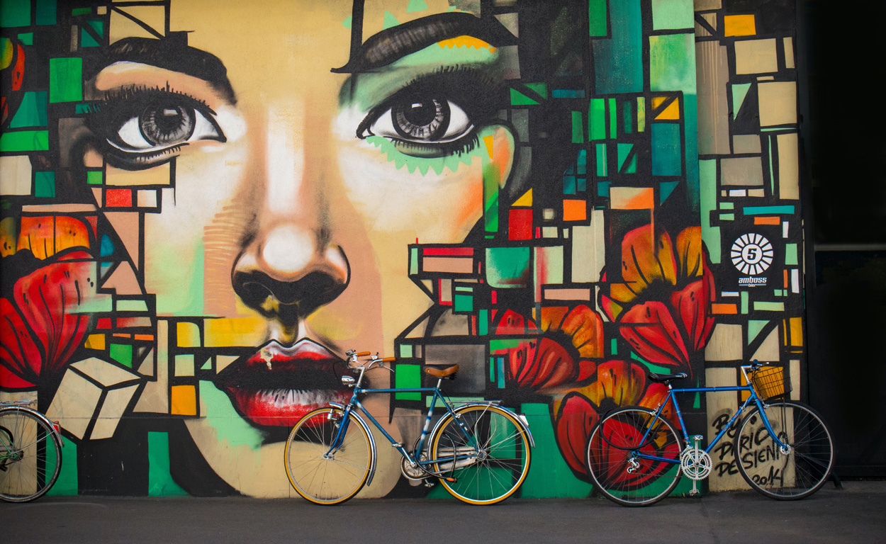bikes sitting against a wall of graffiti