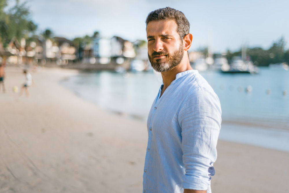 man with beard standing on the beach