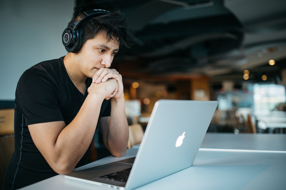 man with headphones on on laptop