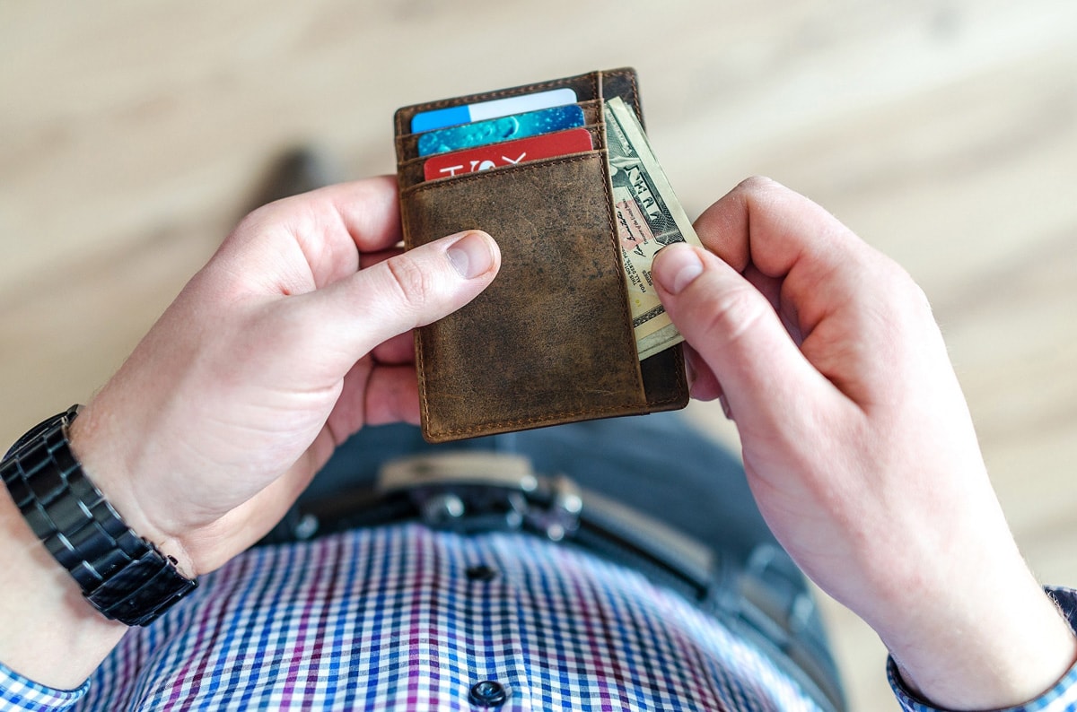 man putting money in his wallet