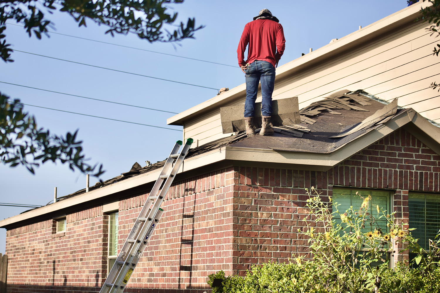 man standing on the roof of a house