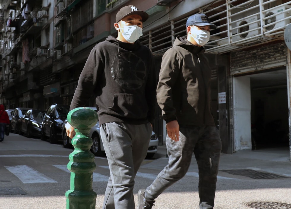 men walking down the street wearing face masks
