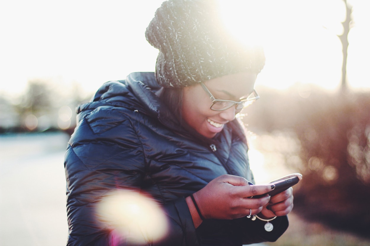 smiling woman using smartphone
