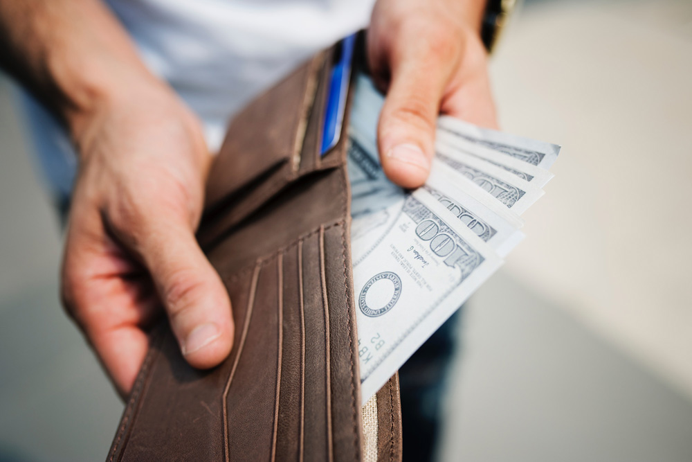 man holding wallet with cash
