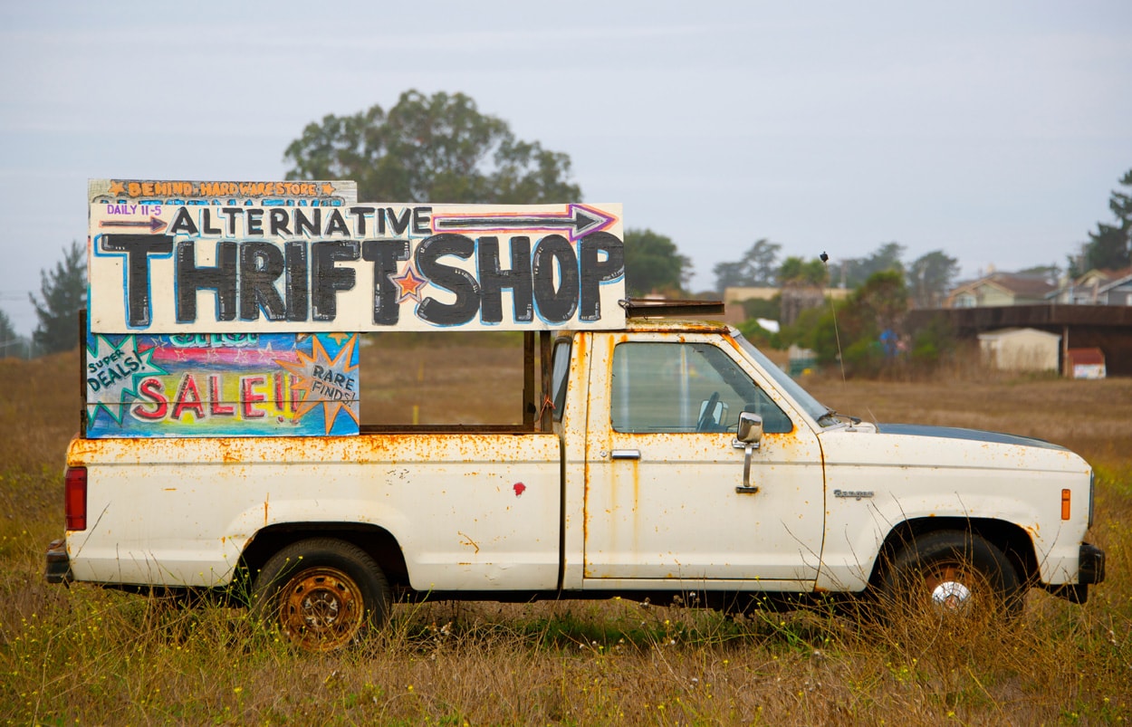 white pickup truck with thrift shop signage