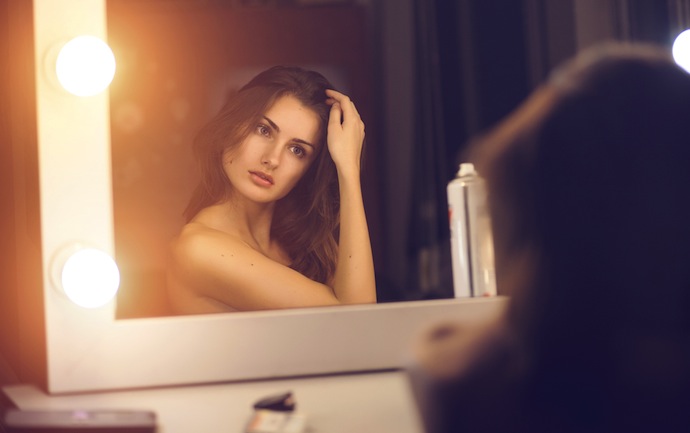 woman looking into mirror at herself