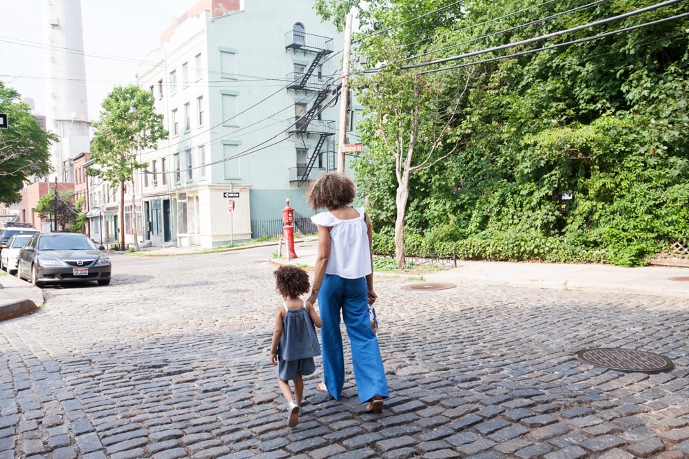 woman walking on cobblestone street with daughter