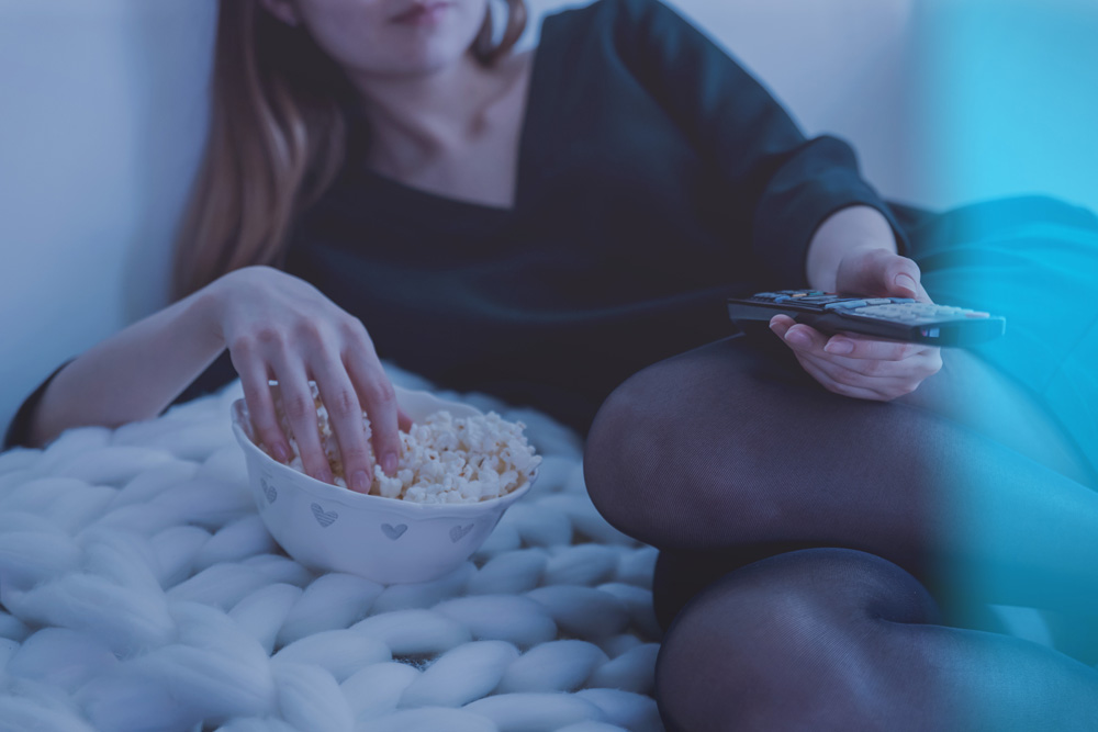 woman watching cable eating popcorn